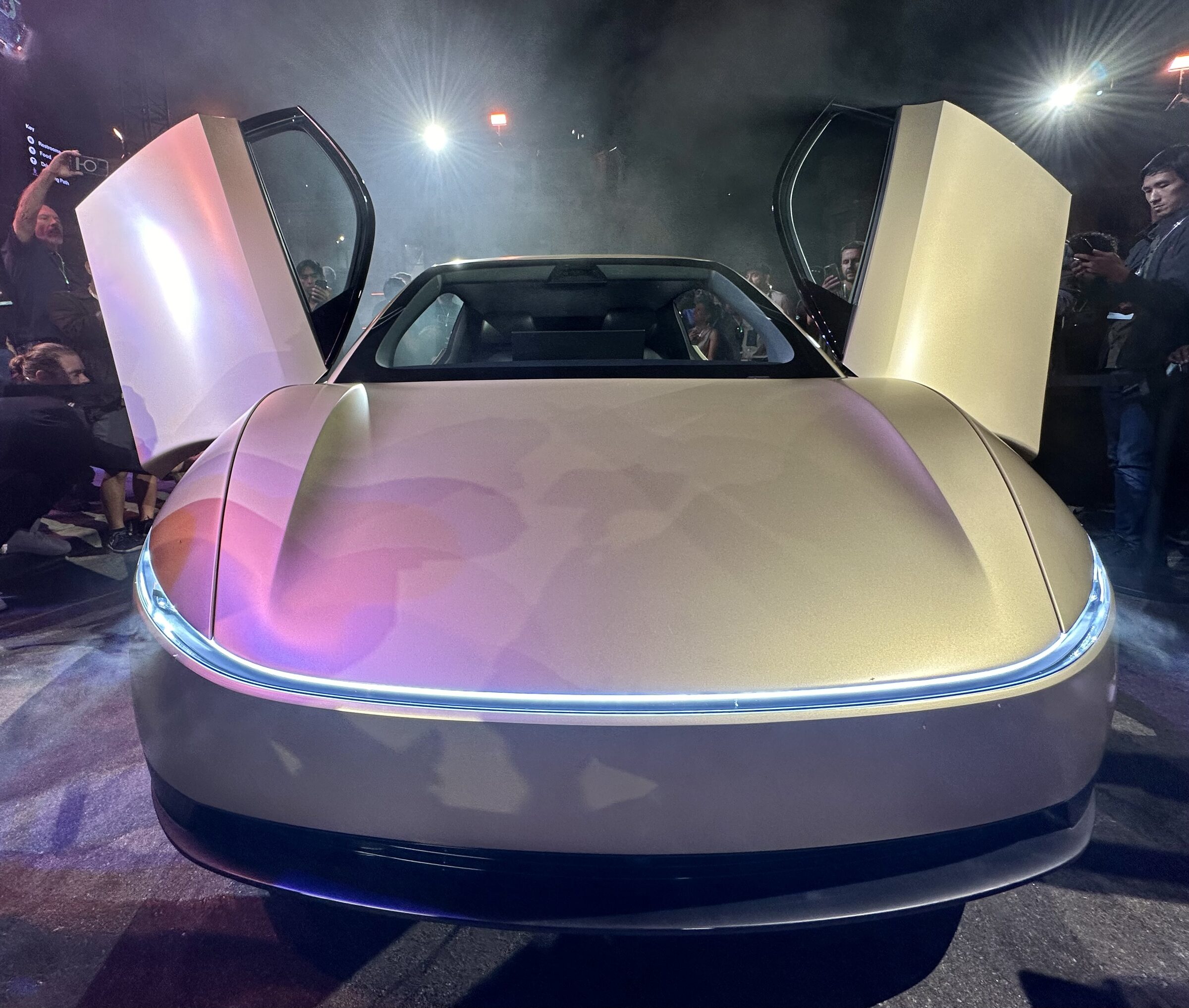 Front of a Tesla Cybercab at a night unveiling.